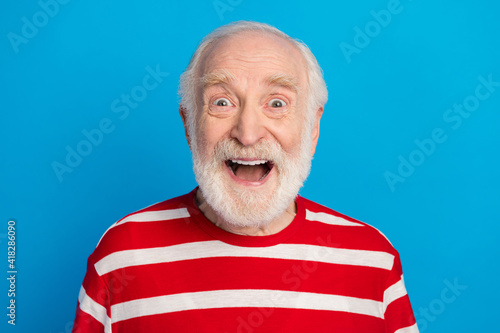 Close-up portrait of attractive cheerful funny amazed grey-haired man isolated over bright blue color background