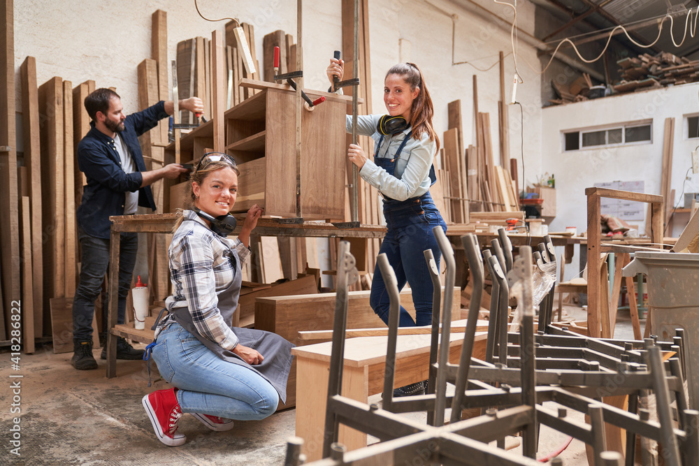 Apprentice furniture makers glue a cabinet Apprentice furniture makers glue a cabinet