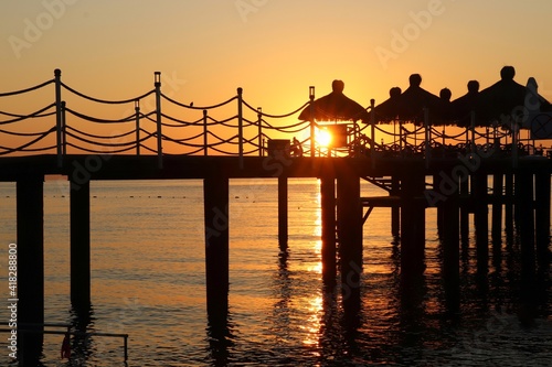 The silhouette of the pier against the background of the sunset and the Mediterranean sea