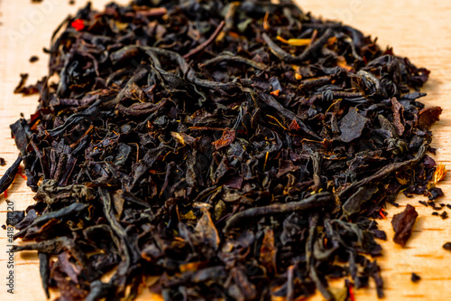 Delicious Black tea flavored with safflowers petals and bergamot pronounced taste. Selected focus Macro close up photography of tea leaves background. Sharp and vivid colors, ideal for advertising. 