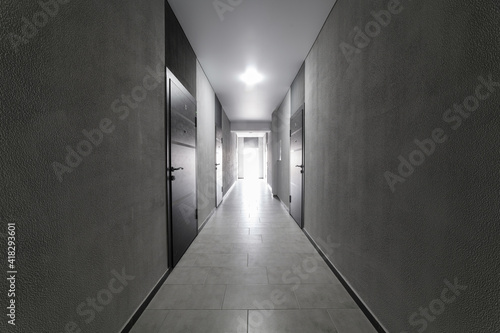 Gray loft-style corridor with light at the end