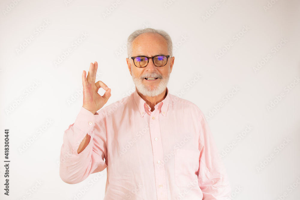 Naklejka premium happy positive handsome old man shows okay sign over white background.