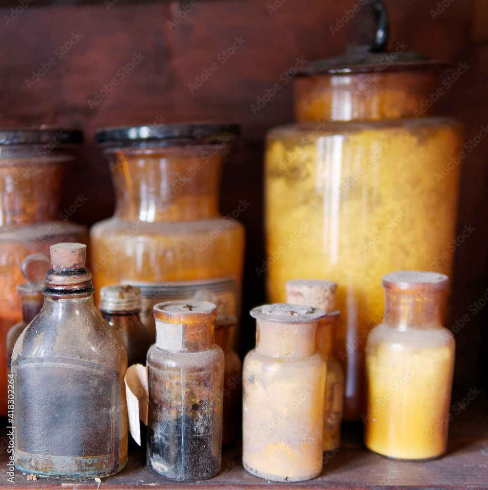 A bottle of poison on a background of old medical, chemistry and pharmacy glass. Chemistry and pharmacy history panoramic concept background. A bottle of poison on a background of old medical, chemistry and pharmacy glass. Chemistry and pharmacy history panoramic concept background.