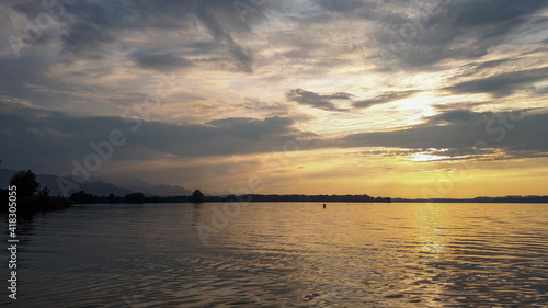 Mesmerizing sunset sky at lake Chiemsee in summer. Tranquil atmosphere in the evening with golden sunset