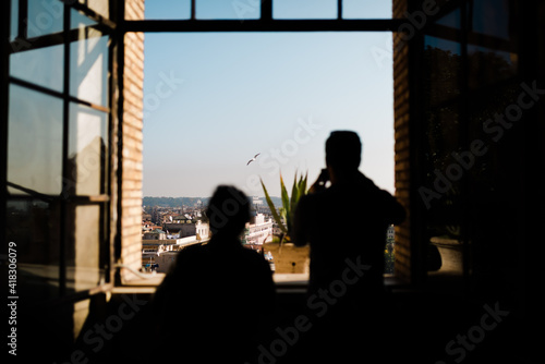Silhouette of two people taking pictures of the city