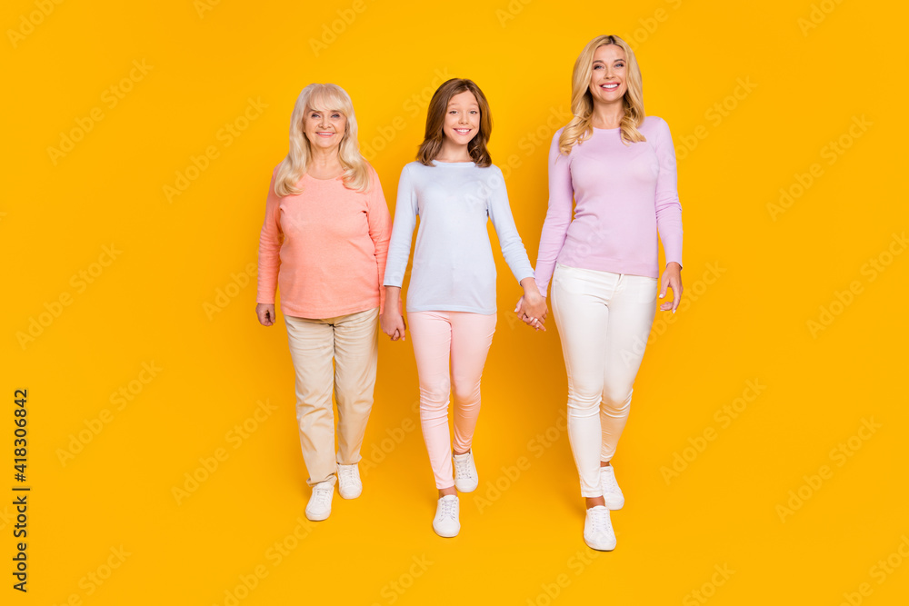 Naklejka premium Full size photo of nice optimistic three woman grand mom daughter go wear pastel cloth isolated on yellow color background