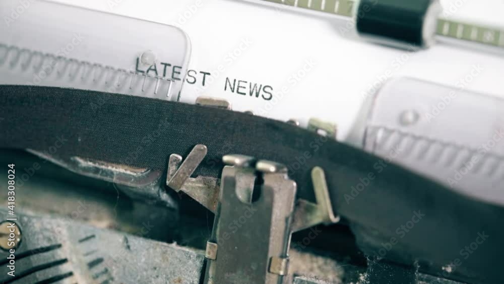 close-up view of typing words LATEST NEWS on vintage typewriter close-up view of typing words LATEST NEWS on vintage typewriter