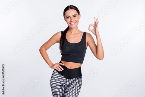 Photo of happy good mood smiling cheerful sportive athlete woman showing okay sign isolated on white color background