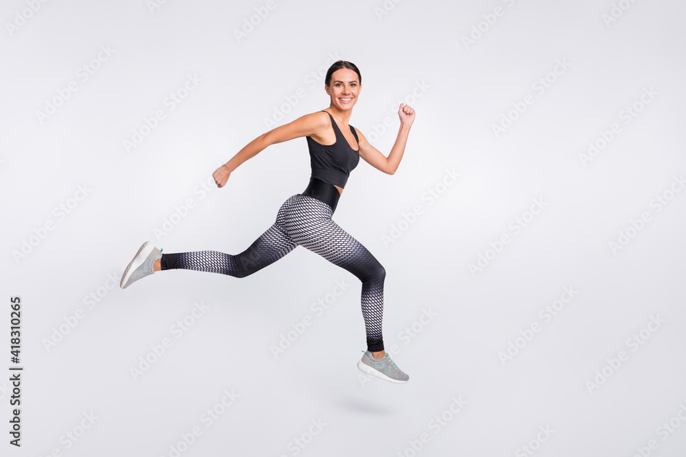 Full body profile side photo of brunette ponytail haired woman jump up air runner isolated on grey color background Full body profile side photo of brunette ponytail haired woman jump up air runner isolated on grey color background