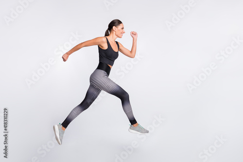 Full size profile side photo of brown haired ponytail lady jump up run empty space isolated on grey color background