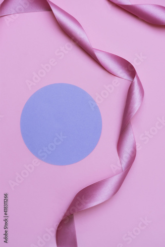 Pink ribbon and purple circle on the pink background. Copyspace background.