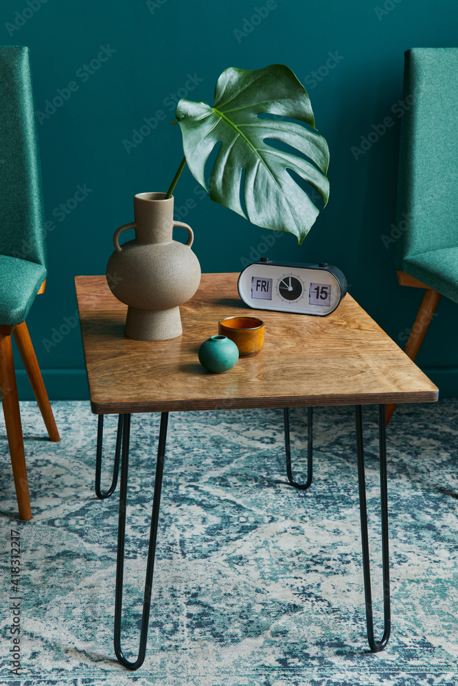 Stylish concept of living room interior with small walnut table, design  chairs, tropical leaf in beige vase, clock, retro carpet, decoration and  accessories in modern vintage home decor. Stock-Foto | Adobe Stock