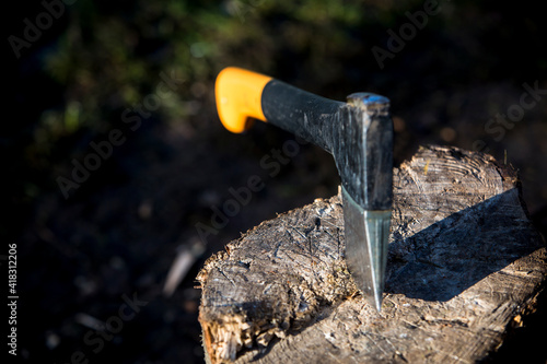 an black and yellow axe in wood outdoors