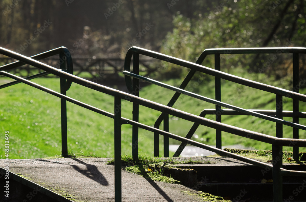 HANDRAILS ON THE COUSEWAY - Infrastructure of a walking trail by a brook in the park HANDRAILS ON THE COUSEWAY - Infrastructure of a walking trail by a brook in the park