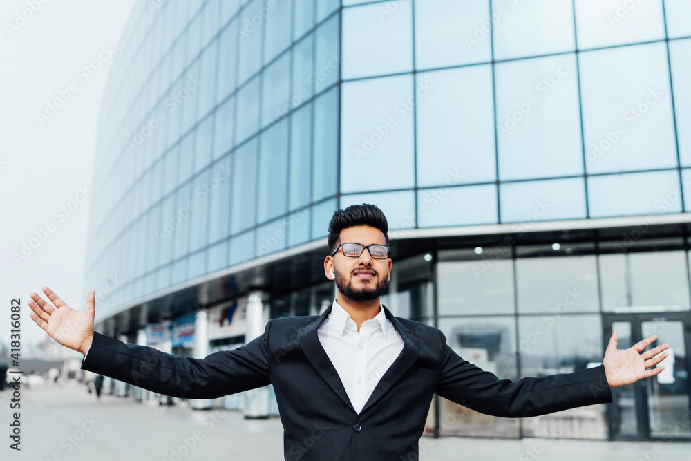 Bearded successful Indian businessman in front of his modern big business center, managing Indian businessman Bearded successful Indian businessman in front of his modern big business center, managing Indian businessman