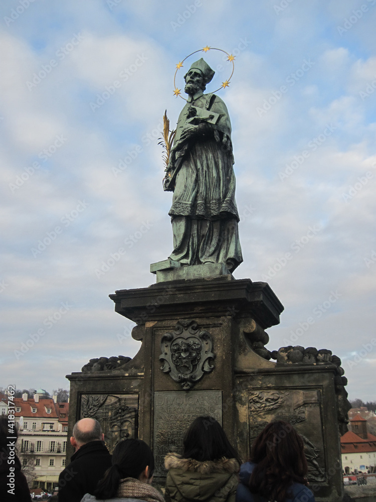 Obraz premium Religious stone sculptures of the Charles Bridge in Prague on a cloudy day.