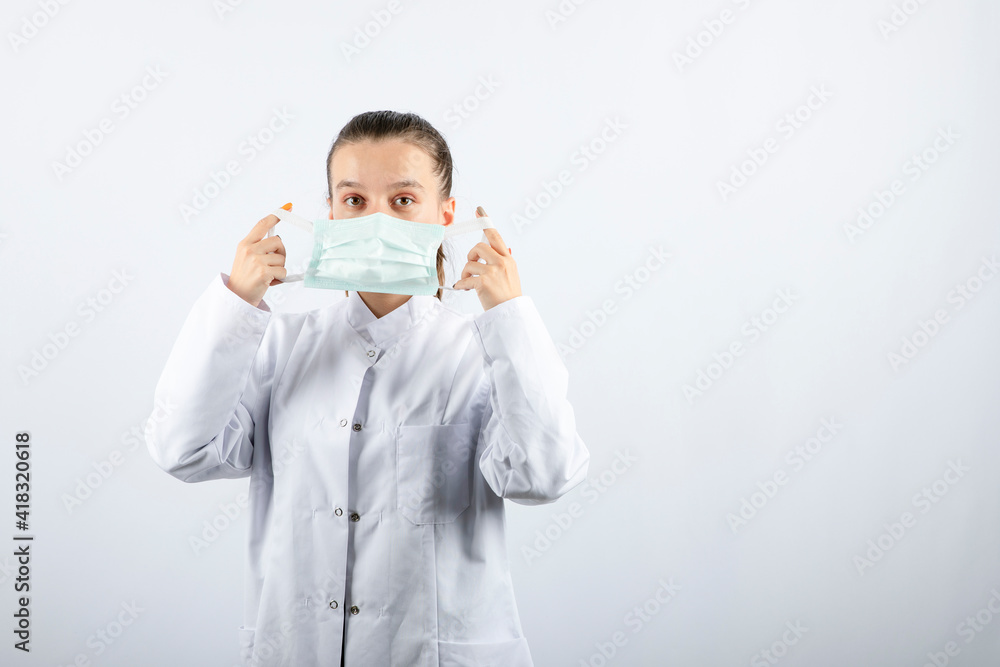 Woman doctor in white uniform wearing a medical mask Woman doctor in white uniform wearing a medical mask