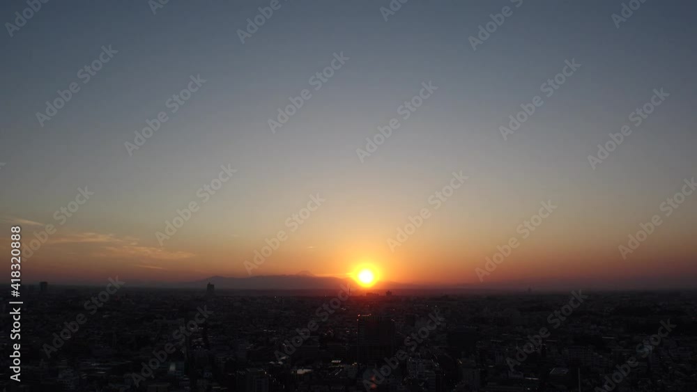 TOKYO, JAPAN : Aerial high angle sunset CITYSCAPE of TOKYO and MOUNT FUJI. View of sinking huge sun and buildings. Japanese urban city life and metropolis concept. Long time lapse shot dusk to night. TOKYO, JAPAN : Aerial high angle sunset CITYSCAPE of TOKYO and MOUNT FUJI. View of sinking huge sun and buildings. Japanese urban city life and metropolis concept. Long time lapse shot dusk to night.