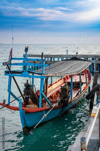 an asian adult standing on his fishing boat to start work day on morning at the island driving for people as a taxi © MarWansh