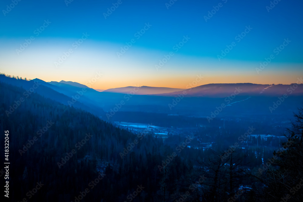 Dark evening sky over Zakopane, Poland. Colorful sunset in a cloudless sky, Tatra National Park. Selective focus on the mountain ridge, blurred background.