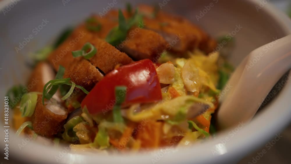 Fried chicken dish with vegetables on a plate. Close up view of traditional Asian dish with fried chicken served on the table Fried chicken dish with vegetables on a plate. Close up view of traditional Asian dish with fried chicken served on the table