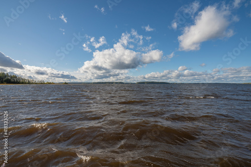 lake water under windy conditions with puffy clouds