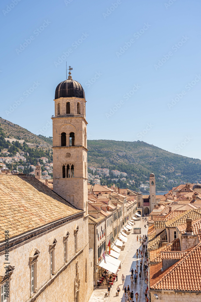 Dubrovnik, Croatia - Aug 22, 2020:Stradun street view of Franciscan church bell tower in morning sunrise in morning