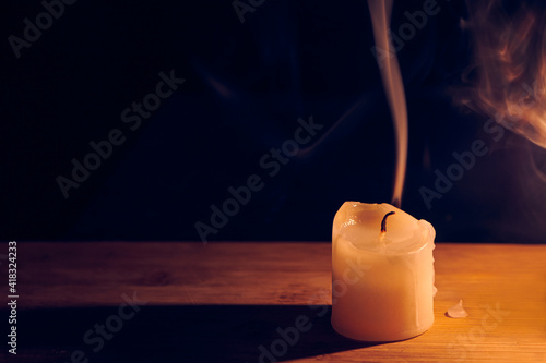 Tableau sur toile Burning and extinguished candle on wooden table. Smooth, white s