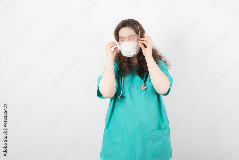 Picture of a young girl in green uniform wearing medical mask Picture of a young girl in green uniform wearing medical mask