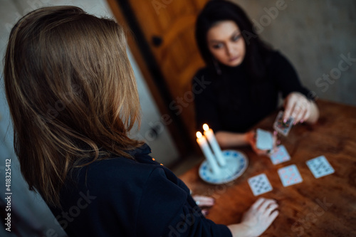 a fortune teller predicts the fate and future of a girl on tarot cards