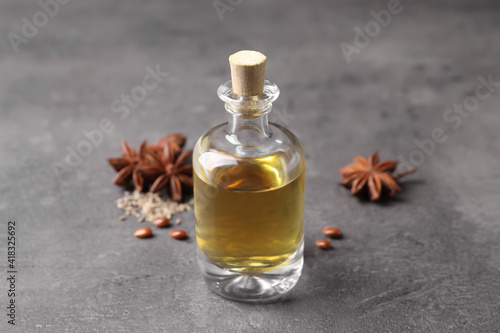 Anise essential oil and spices on grey table