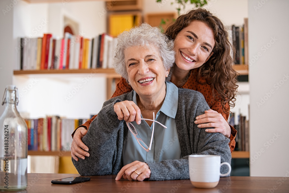 © Rido - Happy granddaughter embracing senior grandmother