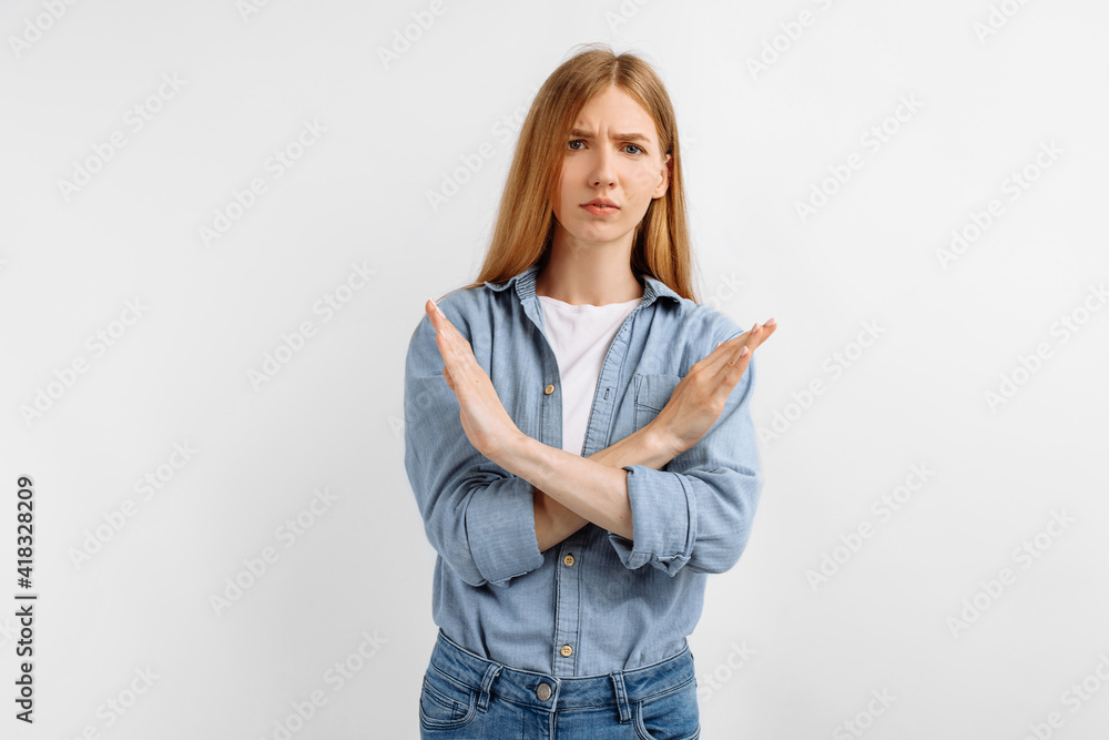 serious young woman, arms crossed, showing stop gesture, on white background serious young woman, arms crossed, showing stop gesture, on white background