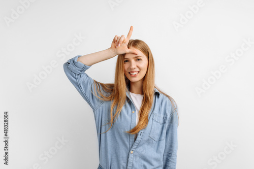 Bild auf Leinwand young woman showing loser gesture upset with defeat against white background