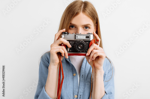 beautiful young woman taking photo on retro camera isolated on white background