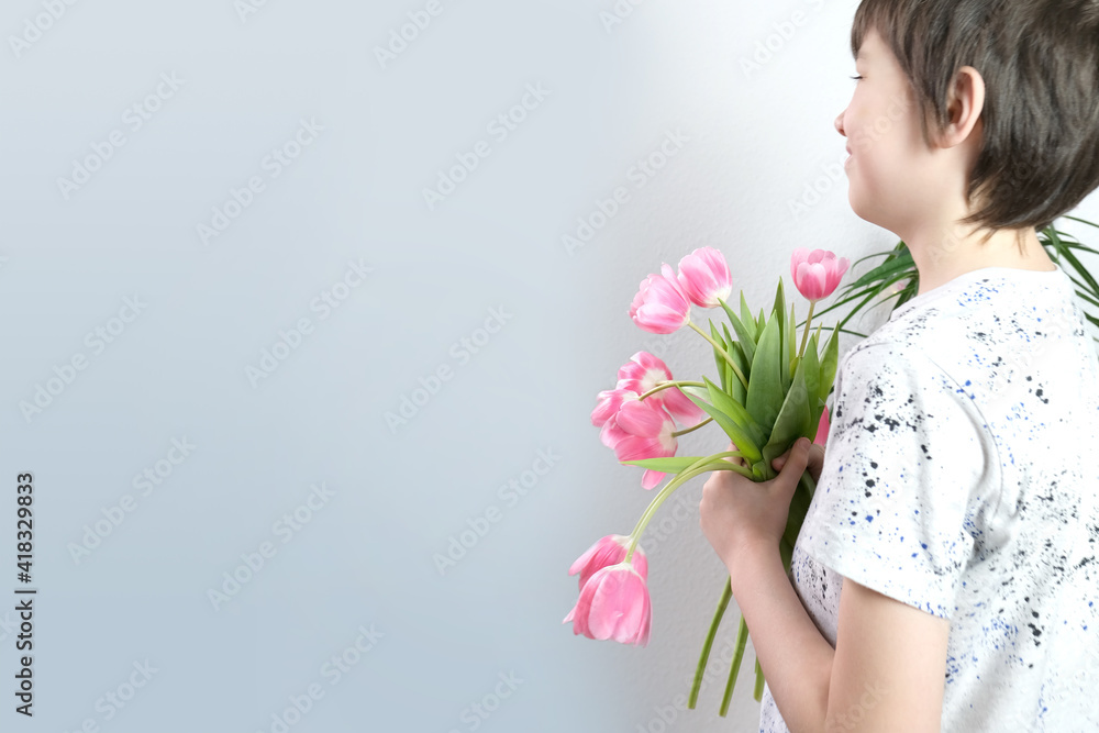 child, boy 8-10 years old holding a bouquet of pink tulips in his hands, the concept of giving fresh flowers, mother's day, birthday, gratitude child, boy 8-10 years old holding a bouquet of pink tulips in his hands, the concept of giving fresh flowers, mother's day, birthday, gratitude