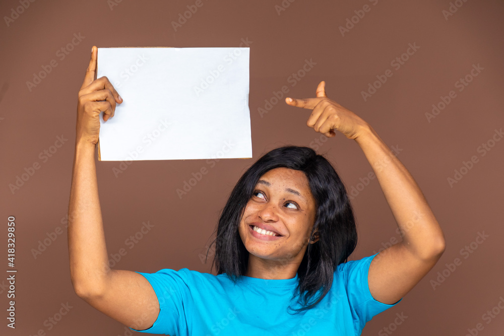 beautiful young nigerian lady holding up an empty sign and pointing to it excitingly, advertising concept beautiful young nigerian lady holding up an empty sign and pointing to it excitingly, advertising concept