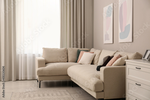 Stylish living room interior with modern comfortable sofa and pictures