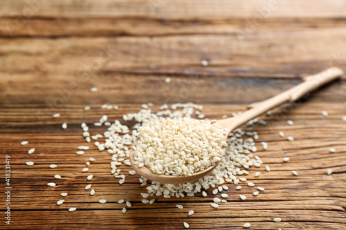 White sesame seeds on wooden table, closeup photo