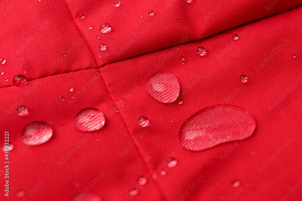 Fototapeta premium Red waterproof fabric with water drops as background, closeup