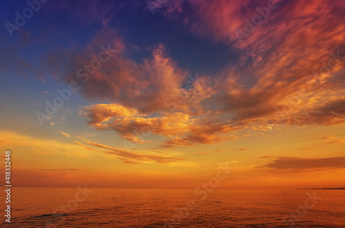 Beautiful sunset, dawn, over the sea, ocean, against the background of the blue sky and colorful clouds