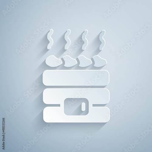 Paper cut Hot sauna stones icon isolated on grey background. Spa resort recreation, bathhouse relaxation. Hot stones on electric heater. Paper art style. Vector.