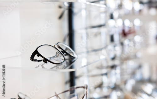 Selective focus at glasses frame on the shelf inside of the store for customer choice and selection. With different color and style. Optometrist and eye vision store or business.
