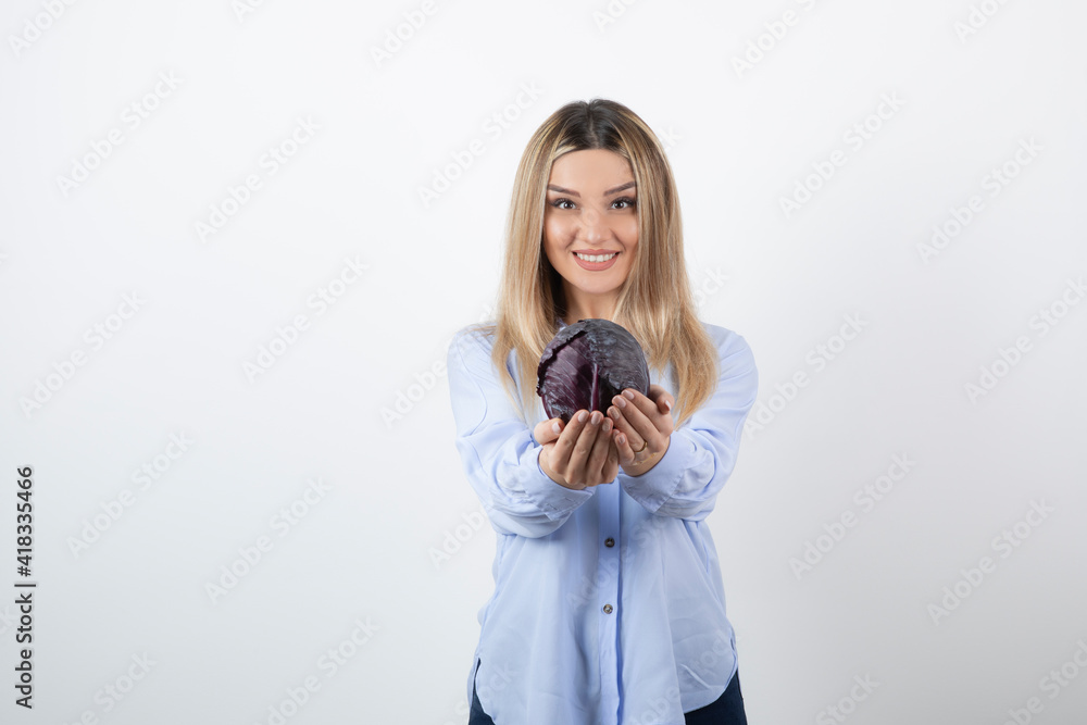 Pretty woman in blue outfit posing with single cabbage on white background Pretty woman in blue outfit posing with single cabbage on white background