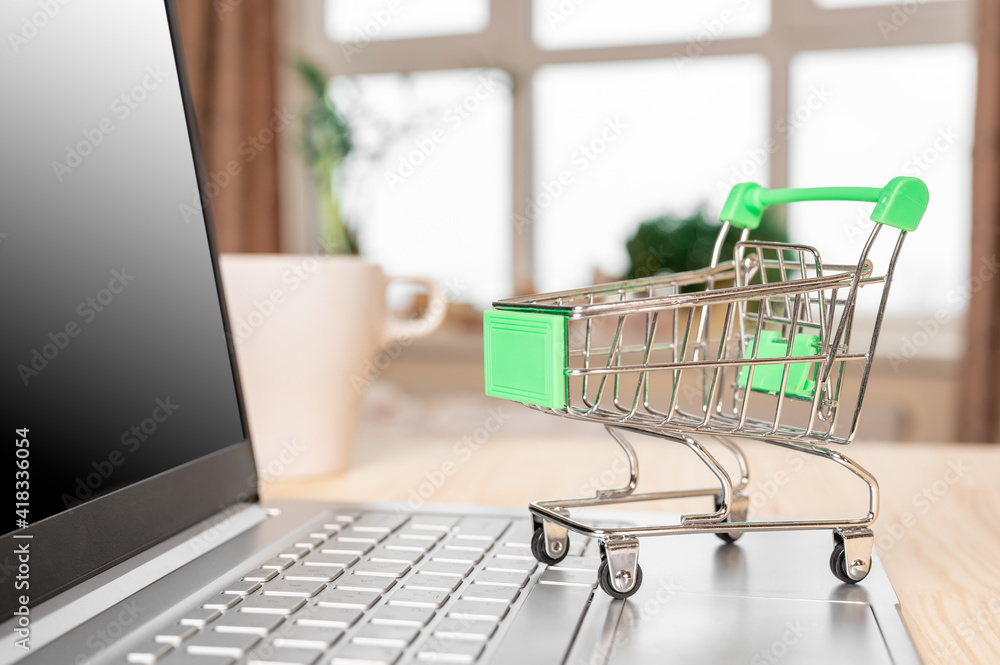 laptop and grocery trolley. Online shopping concept. Shopping Cart on Laptop.