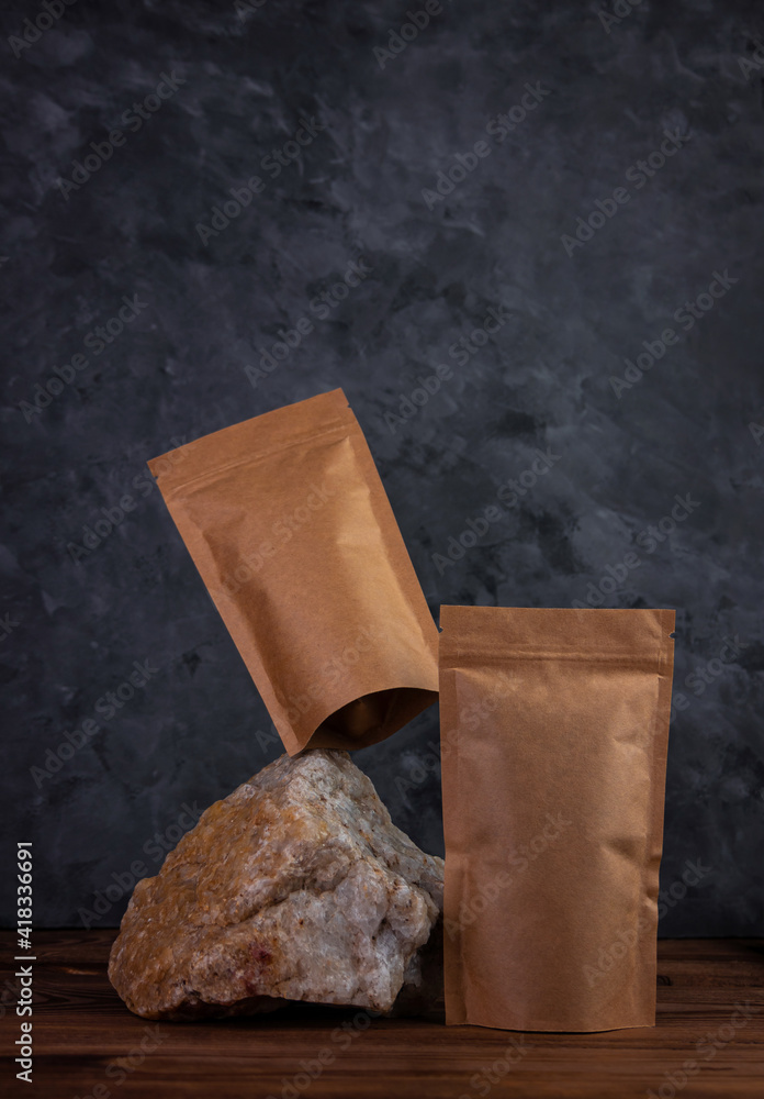 Balancing pouch bag mockup on natural stone. Blank kraft paper pack with coffee beans dark background. Equilibrium floating balance. Advertising food delivery packaging template. Shop sale ad design.