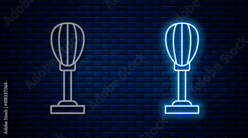 Glowing neon line Punching bag icon isolated on brick wall background. Vector.