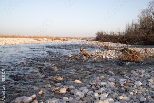 River landscape with shrubs and rubble in the riverbed in a sunny day.