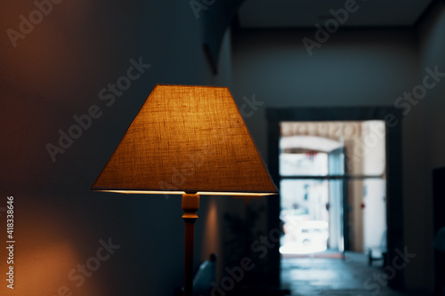 orange lampshade in front of blurred open window