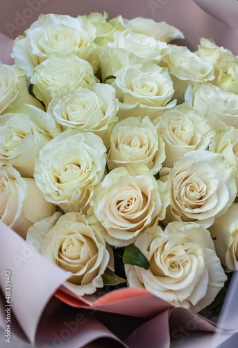 Bouquet of white flowers roses in pink paper closeup